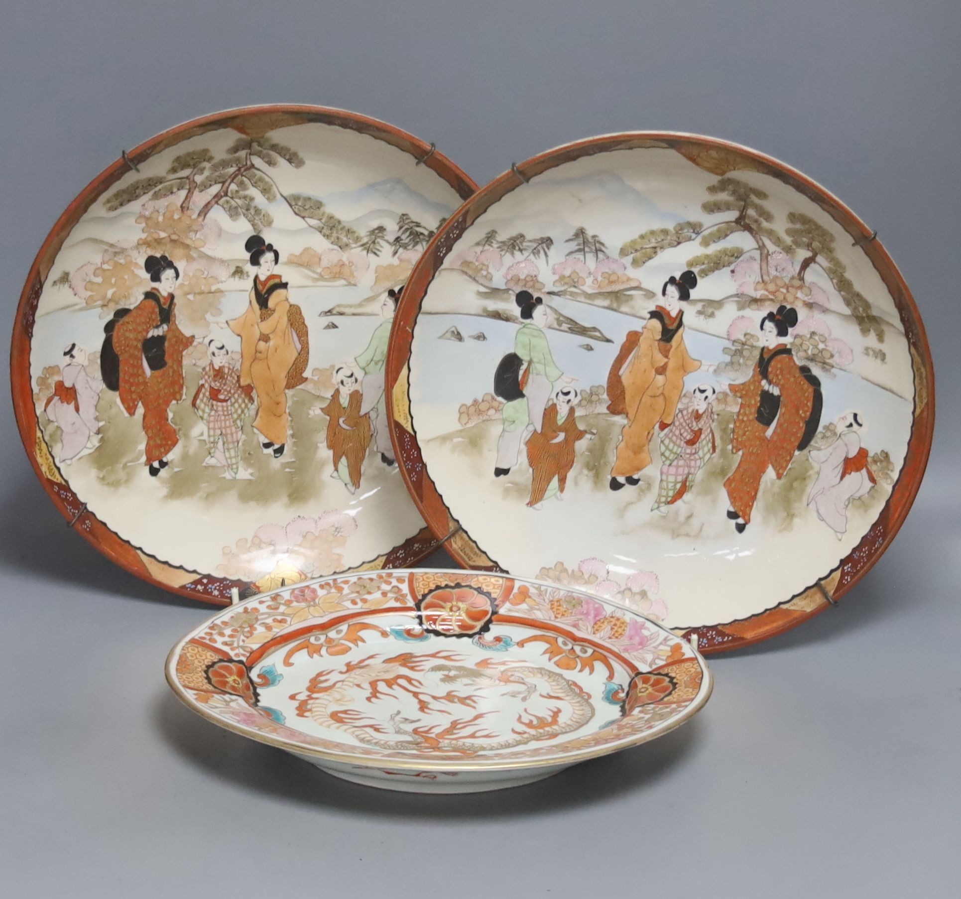 A late 19th century Japanese porcelain oval dish, 29cm, and a pair of Kutani style wall plates, 30cm